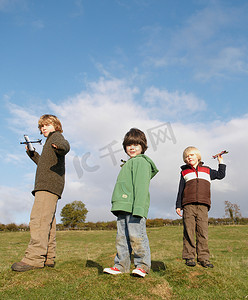 男孩们在田野里扔玩具飞机