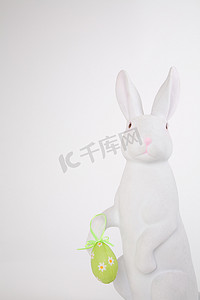 神话人物摄影照片_拿着复活节彩蛋的复活节兔子