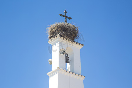 西班牙教堂钟楼顶部的大型鸟巢的低角视角