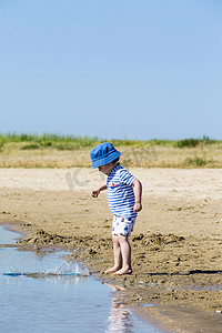 海滩上的小男孩把沙子扔进海里法国夏伦特海事