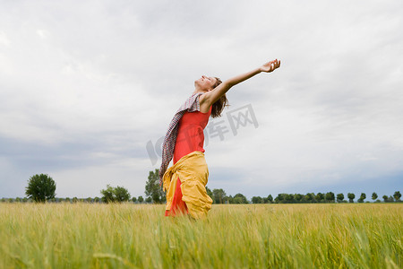 微笑的女人站在高高的草丛中