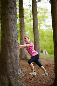 女人跑着靠在树上伸展身体