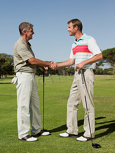 两个成熟的男人在高尔夫球场握手