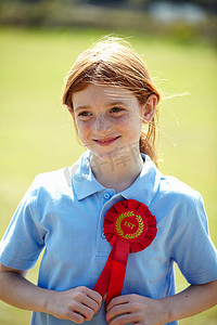 摄影照片_微笑的女孩戴着第一名的丝带