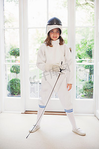 击剑训练摄影照片_穿着击剑装备的女孩在客厅里