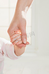 一只母亲的手牵着婴儿的手