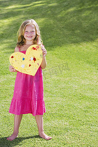 爱情标题摄影照片_年轻的女孩抱着纸的心