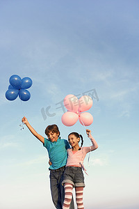 两个孩子拿着气球笑