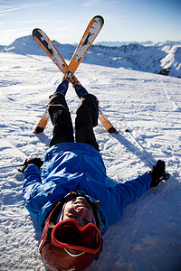 电线杆雪地摄影照片_滑雪板上的孩子躺在雪地里
