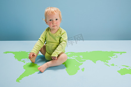 坐在地板上的世界地图上的女婴