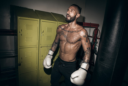 纹身男拳击手在健身房戴着拳击手套做好准备