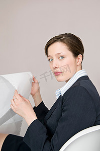 一位手持计算机纸的商务女性