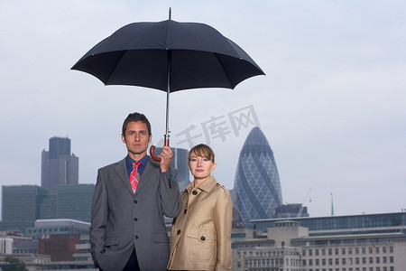 穿着雨伞城市风景画的男人和女人