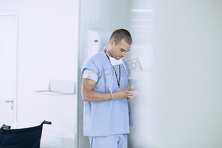 一名男医生在医院病房使用智能手机
