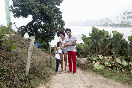 热男孩摄影照片_巴西里约热内卢伊帕内马海滩上的夫妇和儿子的肖像