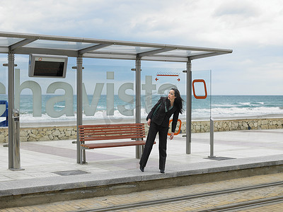 西班牙女摄影照片_年轻女商人在电车站等车