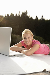 一名使用笔记本电脑的年轻女子面带微笑