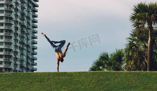 手倒立摄影照片_美国佛罗里达州迈阿密南海滩南角公园成熟男子在草地上单手倒立