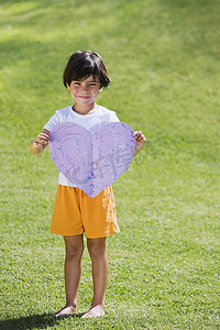 爱情标题摄影照片_抱着紫纸心的小男孩