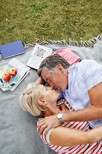 成熟情侣在野餐毯子上接吻