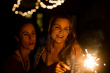 潮摄影照片_成熟的女性朋友晚上在花园里玩火花