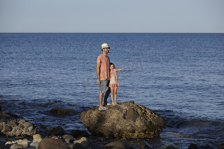 水摄影照片_西班牙加泰罗尼亚科斯塔布拉瓦父亲和女儿站在海上的岩石上