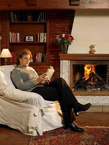 老年妇女在火中看书