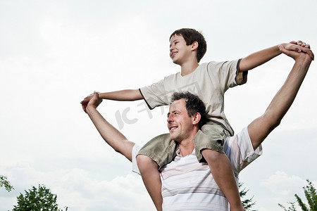 爱情两个人摄影照片_儿子骑在父亲的肩膀上