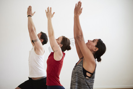 健身房里的人以瑜伽姿势举起手臂