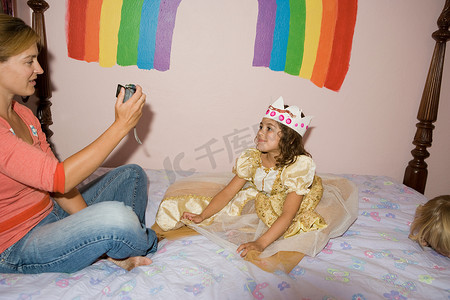 母亲为穿着公主服装的女儿拍照