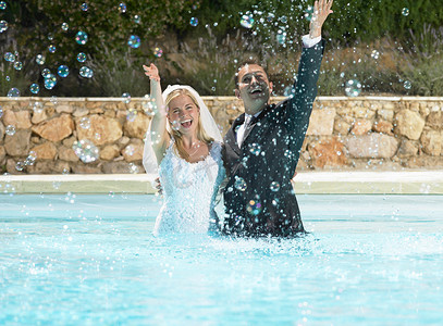 新娘和新郎在泳池里戏水