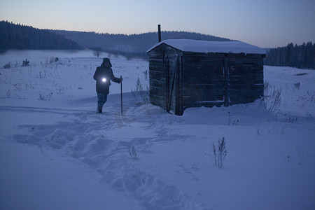 俄罗斯文化摄影照片_俄罗斯斯维尔德洛夫斯克市村黄昏时分白雪覆盖的男子指着火炬