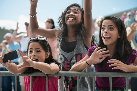 同心同向同心同行摄影照片_三个兴奋的女孩在流行音乐会上