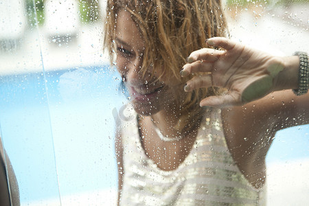 巴西里约热内卢酒店游泳池窗户后的年轻女子