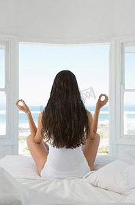 瑜伽姿势的女性坐在床上