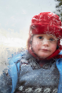 街机摄影照片_男孩看着结霜的窗户