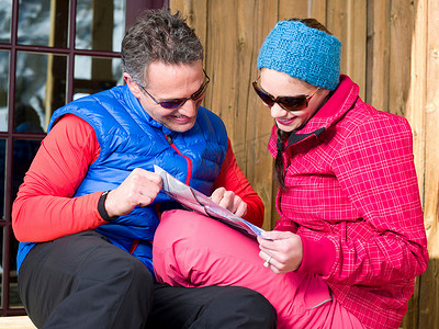 成熟的男人和年轻的女人在滑雪场看地图