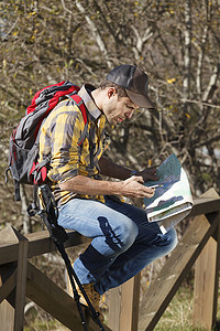 徒步旅行者在木质扶手上阅读地图蒙特塞尼巴塞罗那西班牙加泰罗尼亚