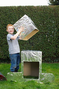 男孩建造纸板宇宙飞船