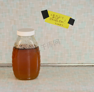 昆虫瓶子摄影照片_带有蚂蚁问题标志的蜂蜜罐头