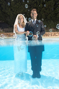 游泳池泡水摄影照片_泡在泳池里的新娘和新郎