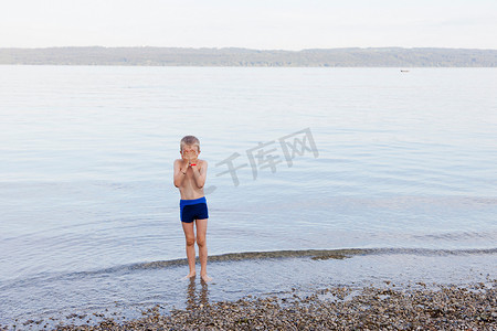 男孩在海滩上蒙着脸