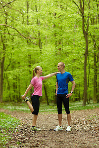 灵活性摄影照片_一对情侣在森林里奔跑伸展身体