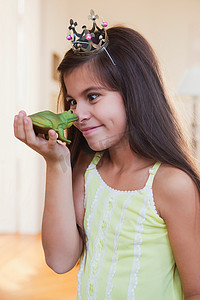 心冠摄影照片_戴皇冠的女孩在玩玩具青蛙