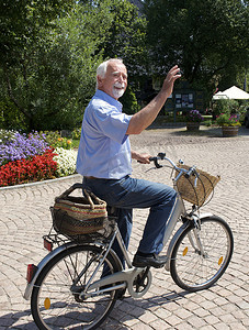 骑自行车穿过公园的老年男子