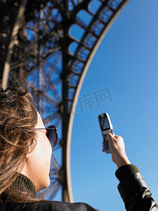 一名女子为埃菲尔铁塔拍照