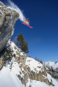 游戏雪山背景摄影照片_雪山上的滑雪者在半空中滑雪