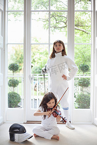 击剑训练摄影照片_带着小提琴和击剑装备的女孩