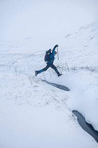 徒步旅行者在雪地上跳跃