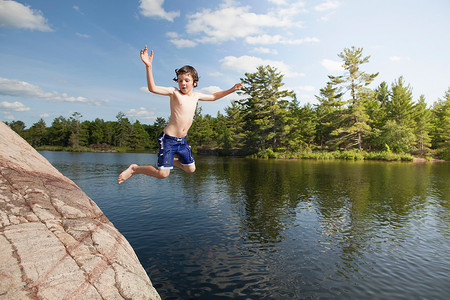 加拿大安大略省摄影照片_跳入静湖的男孩